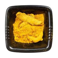 Turmeric Curcuma powder and roots in black bowl photo