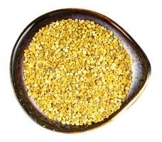 top view of ceramic bowl with natural bee pollen photo