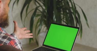 een Mens Aan de bankstel communiceert via video koppeling van een laptop. chroma sleutel