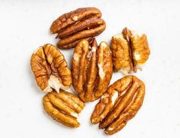 several shelled pecan nuts close up on gray photo