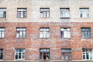 facade of shabby wall of multistorey brick house photo