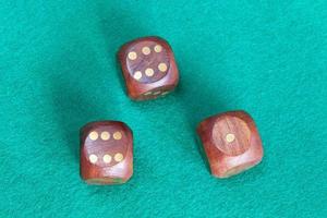 three wooden dices on green baize table photo