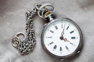 pocket watch with chain on textile background photo