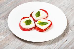 pilas de queso mozzarella en rodajas, tomate, albahaca foto