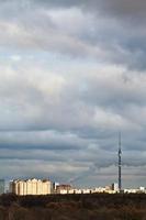 evening clouds over houses and TV tower photo