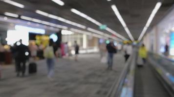 amplio metraje borroso. gente caminando en la pasarela peatonal, apresurándose en la puerta de embarque en la terminal del aeropuerto internacional don mueang, viaje a destinos de viaje con equipaje en el vestíbulo de salida video