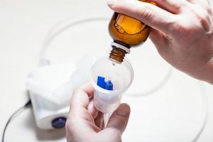 dripping solution from vial into nebulizer photo