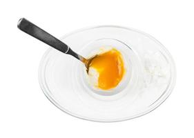 top view of open egg with spoon in glass egg cup photo