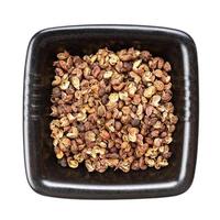 dried pink sichuan pepper in black bowl isolated photo