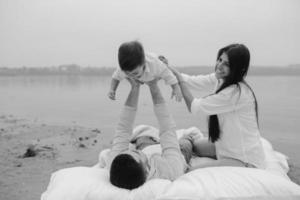 Happy young family relaxing together on the lake photo