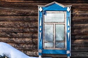 frozen window in wall of rural house in winter photo