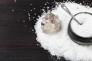 silver salt cellar and raw Halite on table photo