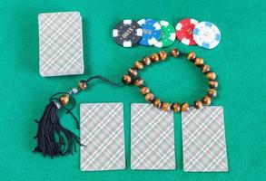 card decks, casino tokens and worry beads on table photo