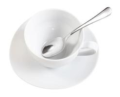 vista anterior de la taza blanca con una cuchara en el plato foto