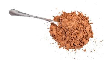 pile of ground carob powder with steel spoon photo