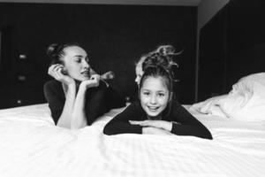 Mom and two daughters have fun on the bed photo