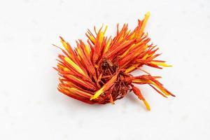 dried safflower bloom close up on gray ceramic photo