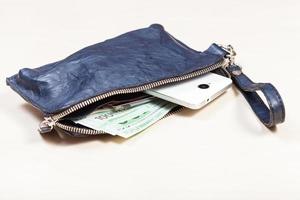 handbag with phone, cards and euro notes on table photo