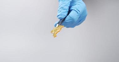 a piece of golden cannabis wax in a hand with a medical glove video