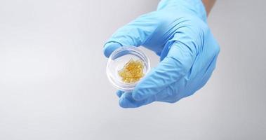 goldenes harzwachs, medizinischer cannabisextrakt in der hand mit medizinischen handschuhen video