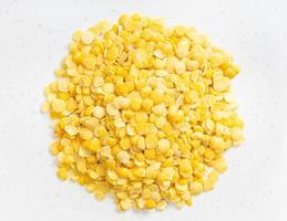 pile of raw split yellow lentils close up on gray photo