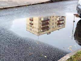 puddle with reflection of municipal urban house photo