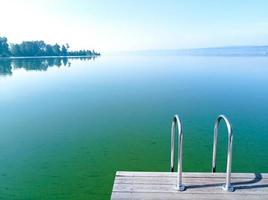 Beautiful view of the blooming green lake with a pier photo