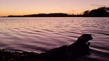 romantischer Blick auf einen See bei Sonnenuntergang mit spiegelnder Wasseroberfläche video