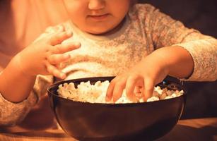 Unrecognizable kid eating popcorn. photo