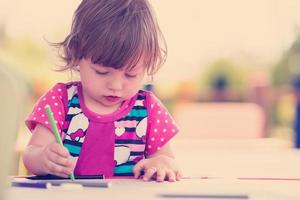 little girl drawing a colorful pictures photo