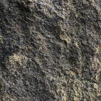 Raw gray granite rock texture background. Fragment of natural stone wall photo