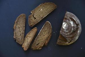 Sliced black bread on a black background. A loaf of black bread with slices of close-up. photo