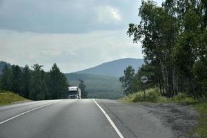 una carretera de alta velocidad en los montes urales en rusia. transporte de carga y pasajeros en la carretera de montaña. foto