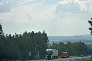 una carretera de alta velocidad en los montes urales en rusia. transporte de carga y pasajeros en la carretera de montaña. foto