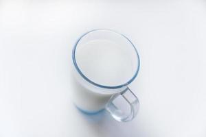 leche en un vaso de vidrio sobre un fondo blanco. un hermoso vaso de leche. foto