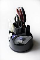 Black office organizer with scissors ruler pens and stapler. photo