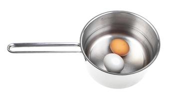 two eggs in saucepan with water isolated photo