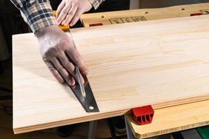 carpenter marks cutting line on wooden board photo