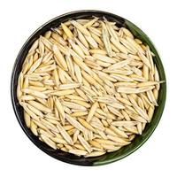 unhulled common oat grains in round bowl isolated photo