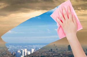 hand deletes smog in city by pink cloth photo