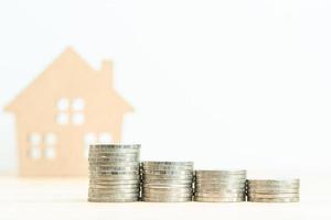 House model and stack of coins on table photo