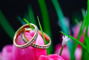 anillo de boda descansando en una flor de tulipán rosa falsa foto