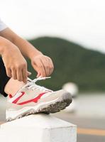 Woman tying shoelace his before starting running photo