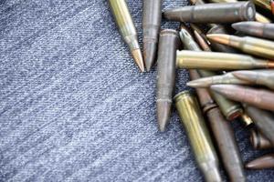 Closeup view of the old bullets on jeans floor, soft and selective focus on bullets, concept for collecting old bullets in free times. photo