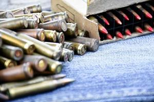 Closeup view of the old bullets on jeans floor, soft and selective focus on bullets, concept for collecting old bullets in free times. photo