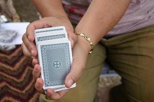 la jugadora de póquer está barajando póquer en sus manos antes de entregar las cartas de póquer a los otros jugadores de póquer, enfoque suave y selectivo en las cartas de póquer. foto