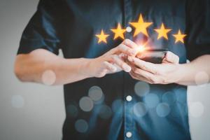 Man using a smartphone in give rating to service experience on application. Online customer review satisfaction feedback survey. photo