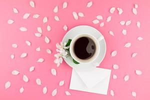 Flat lay of coffee, letter mockup and white petals photo
