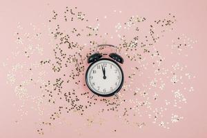 New Year concept. Alarm clock with golden confetti photo