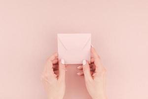 Woman hand holding small pink love letter photo